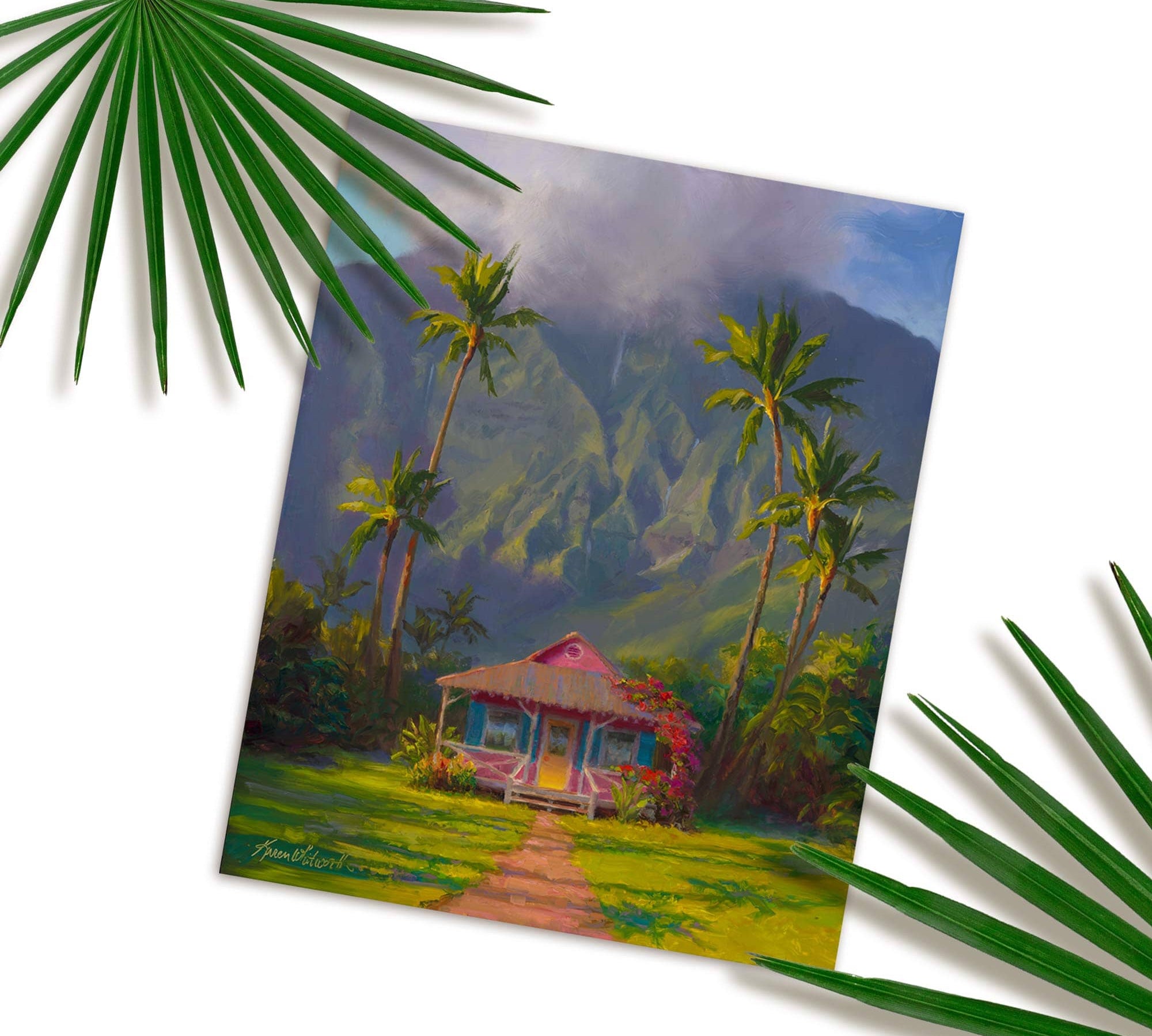 Hawaii art print of Hawaiian painting featuring Hanalei scenery on the island of Kauai in a wall art print titled "Grounded" by artist Karen Whitworth. The print is resting on a white table with green palm fronds next to it.