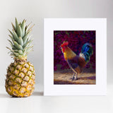 Rooster wall art print of a painting depicting a male chicken standing in front of a flowering bougainvillea bush. The rooster decor print is displayed next to a pineapple.