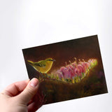 Hand holding a greeting card featuring Hawaiian Amakihi Bird and Koli'i Flower on a white background