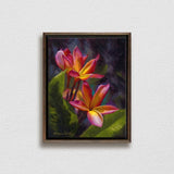Framed wall art canvas of tropical Hawaiian Plumeria flower blossoms on a white wall
