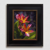 Framed wall art canvas of tropical Hawaiian Plumeria flower blossoms on a white wall