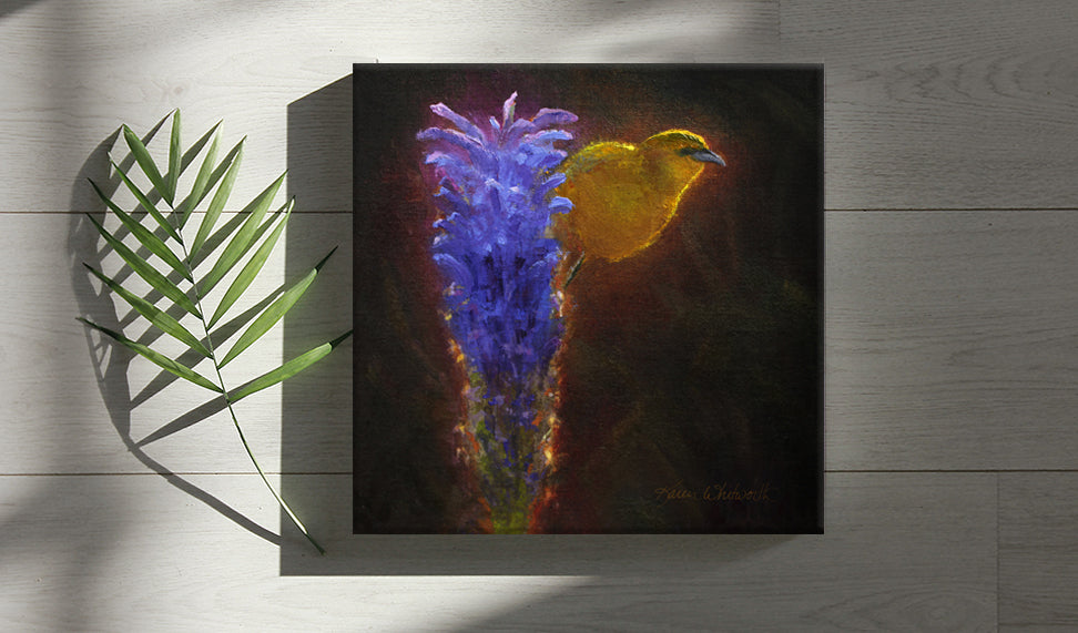 Tropical wall art painting of Hawaiian Amakihi Bird perched on a purple Haleakala Flower, painting by Hawaii Gallery artist Karen Whitworth, resting on white table with palm frond.