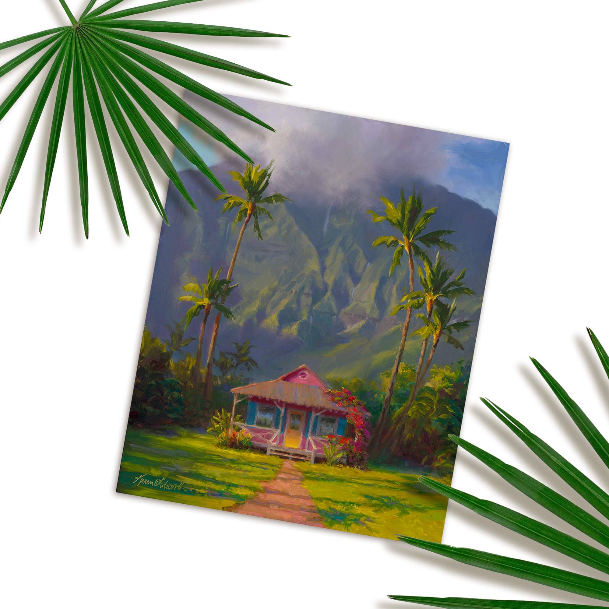 Hawaii art print of Hawaiian painting featuring Hanalei scenery on the island of Kauai in a wall art print titled "Grounded" by artist Karen Whitworth. The print is resting on a white table with green palm fronds next to it.