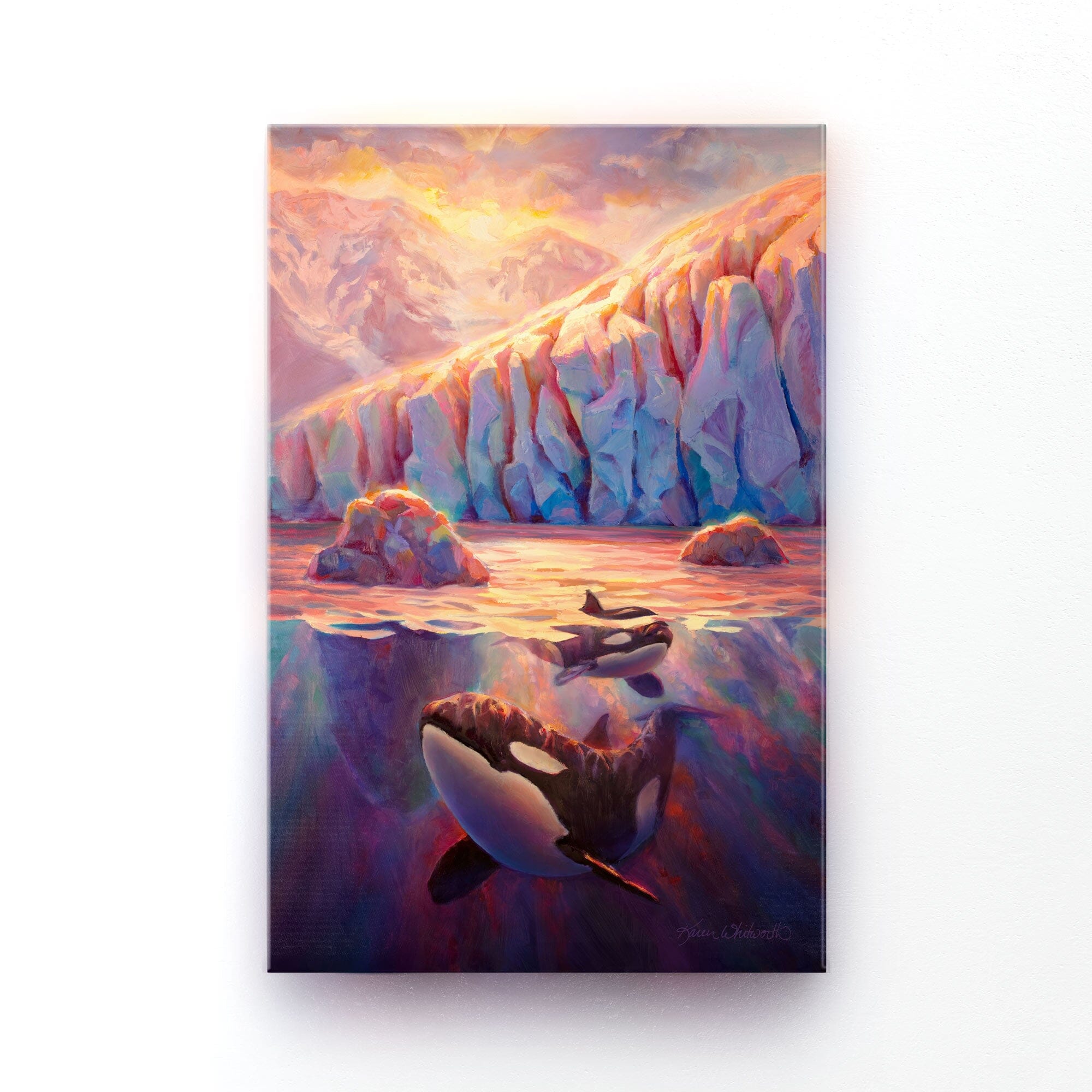 Wall art painting of a glacier sunrise with orca whales by Alaska artist Karen Whitworth. The painting is shown as a canvas print hanging on a white wall.