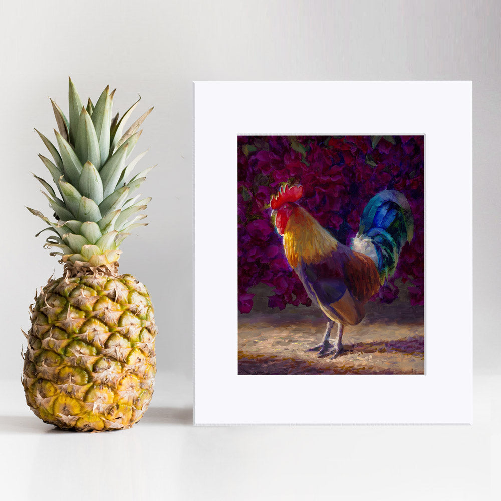 Rooster wall art print of a painting depicting a male chicken standing in front of a flowering bougainvillea bush. The rooster decor print is displayed next to a pineapple.