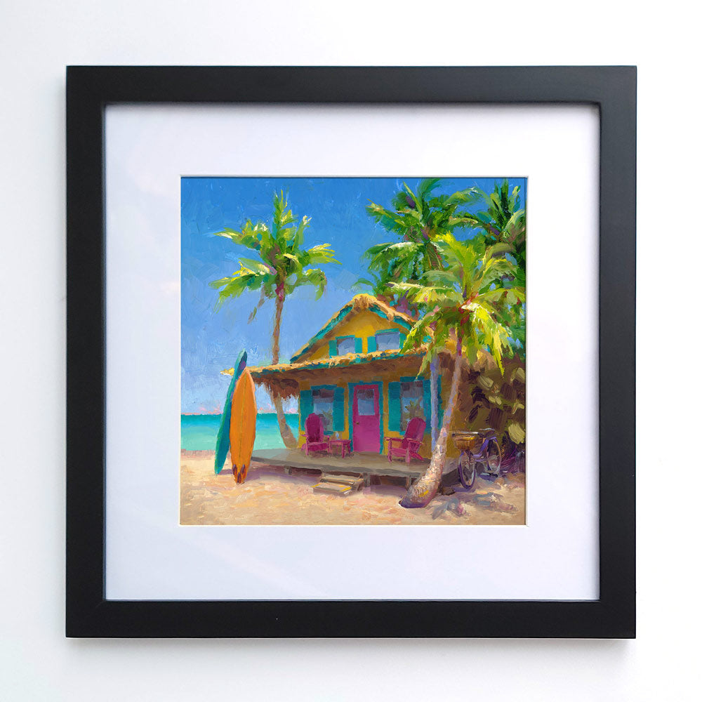 Framed surf wall art print of beach painting with a tropical shack with surf boards leaning on the sunny porch of a dreamy beach house.