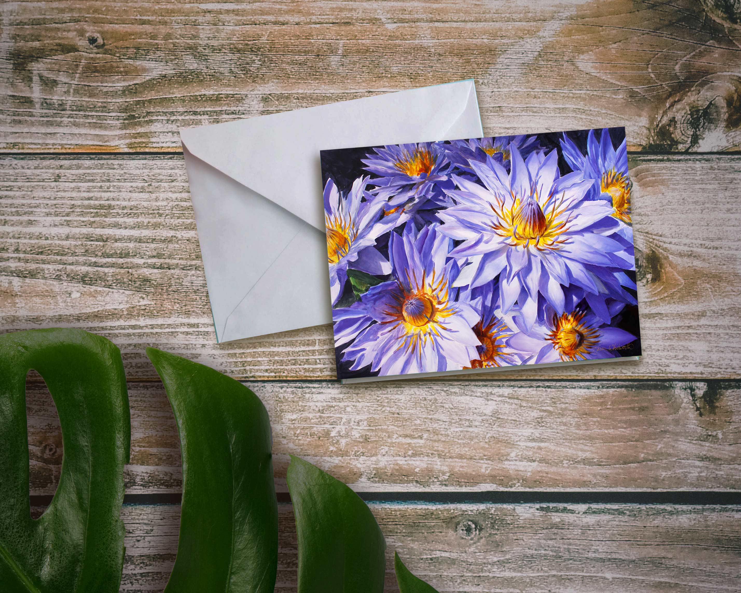 An envelope and card featuring art of tropical Hawaiian Purple Lotus Flowers on wood background