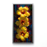 Vertical floral painting of tropical hibiscus flowers by artist Karen Whitworth. The 3 bright yellow flowers sit one on top of the other illuminated in sunlight against a dark background. The painting is framed in a sleek silver contemporary frame and hanging on a white wall. 