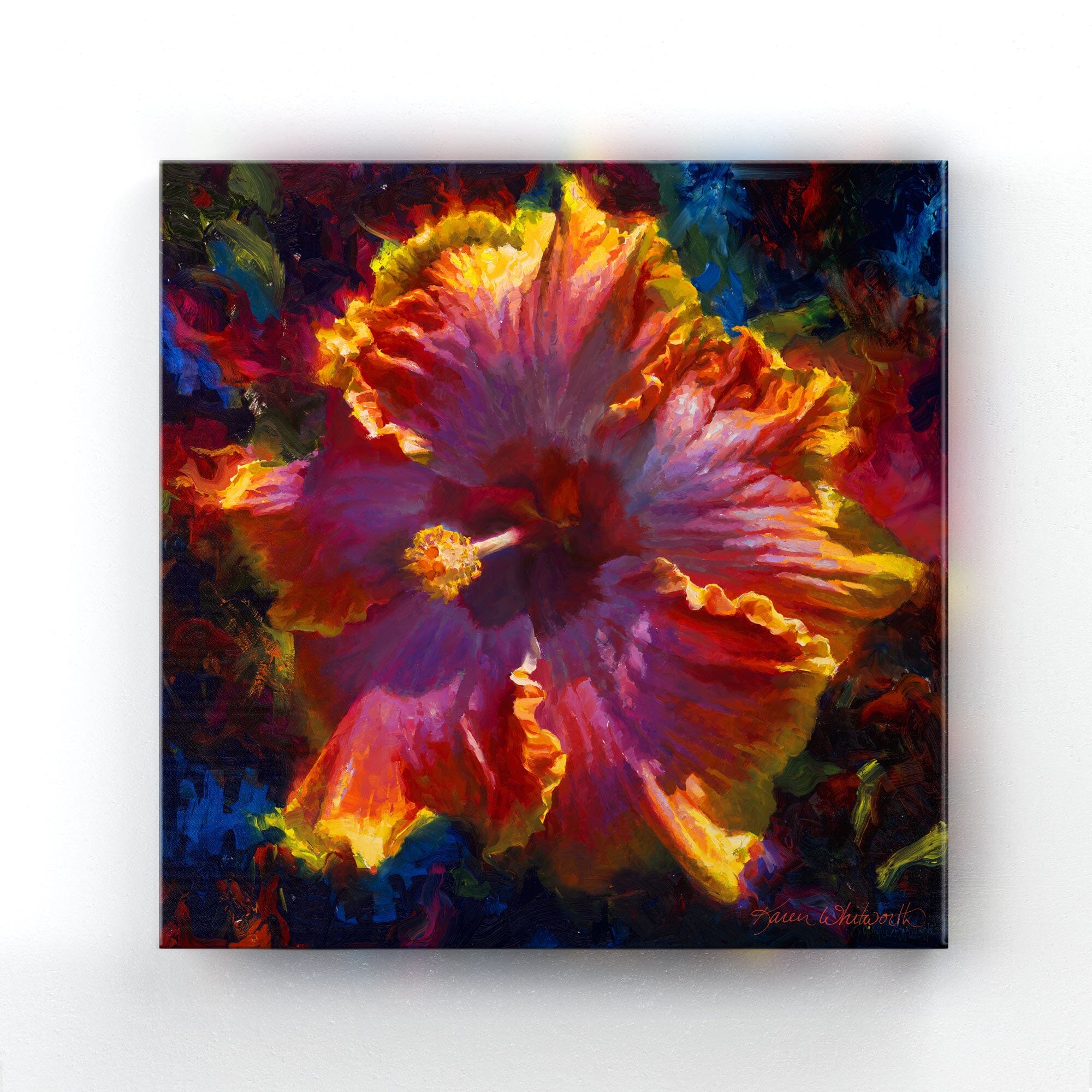 A square Hawaiian hibiscus painting on canvas that is hanging on a white wall. The artwork depicts a rainbow colored flower with ruffled petals and vibrant light full of saturated hues.