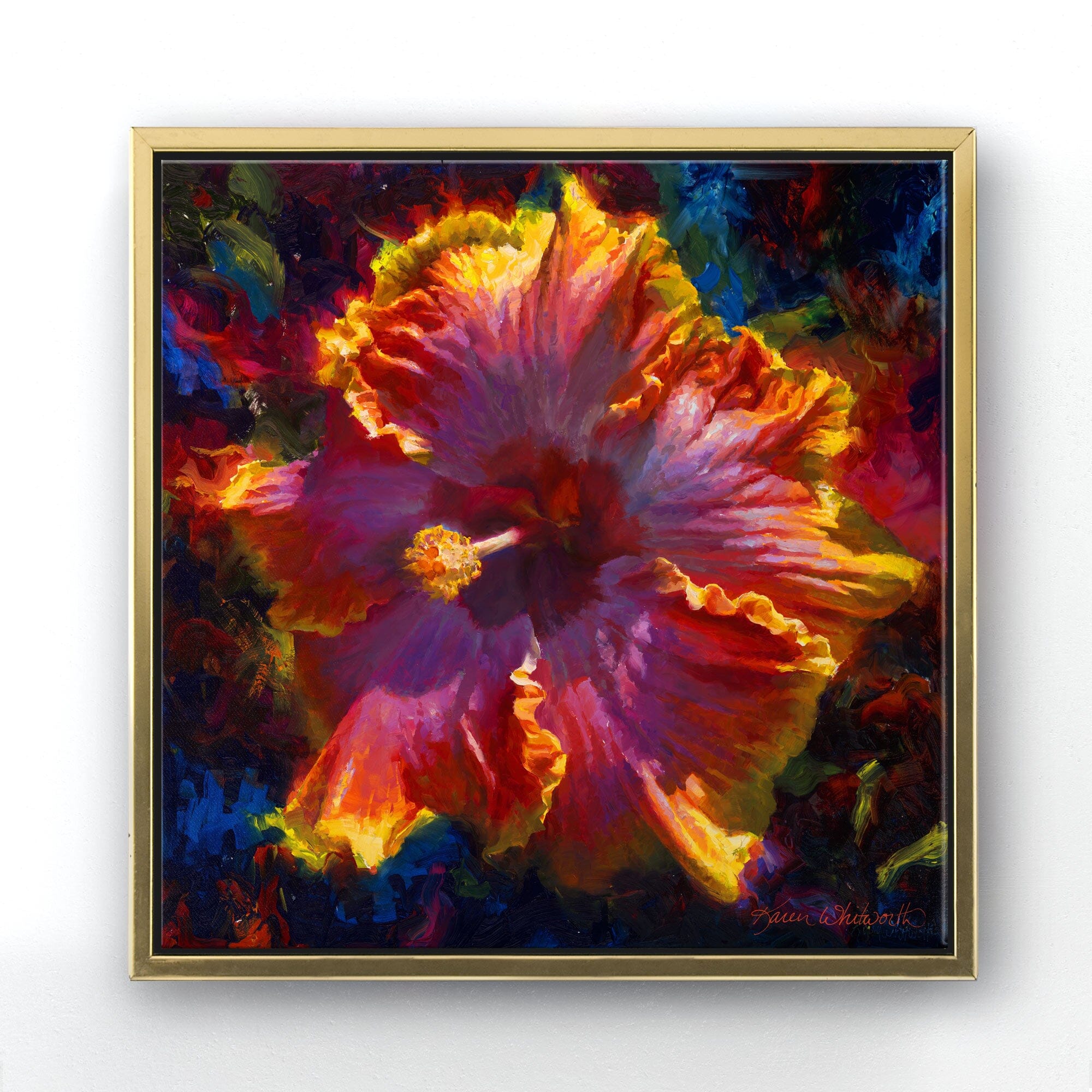 Square canvas wall art in a contemporary gold minimalist frame. The artwork is a painting by Karen Whitworth of a large Hawaiian hibiscus flower, painted in a lively impressionistic style. Vibrant colors and brushstrokes swirl around the flower in a dark background. The painting is hanging on a white wall.